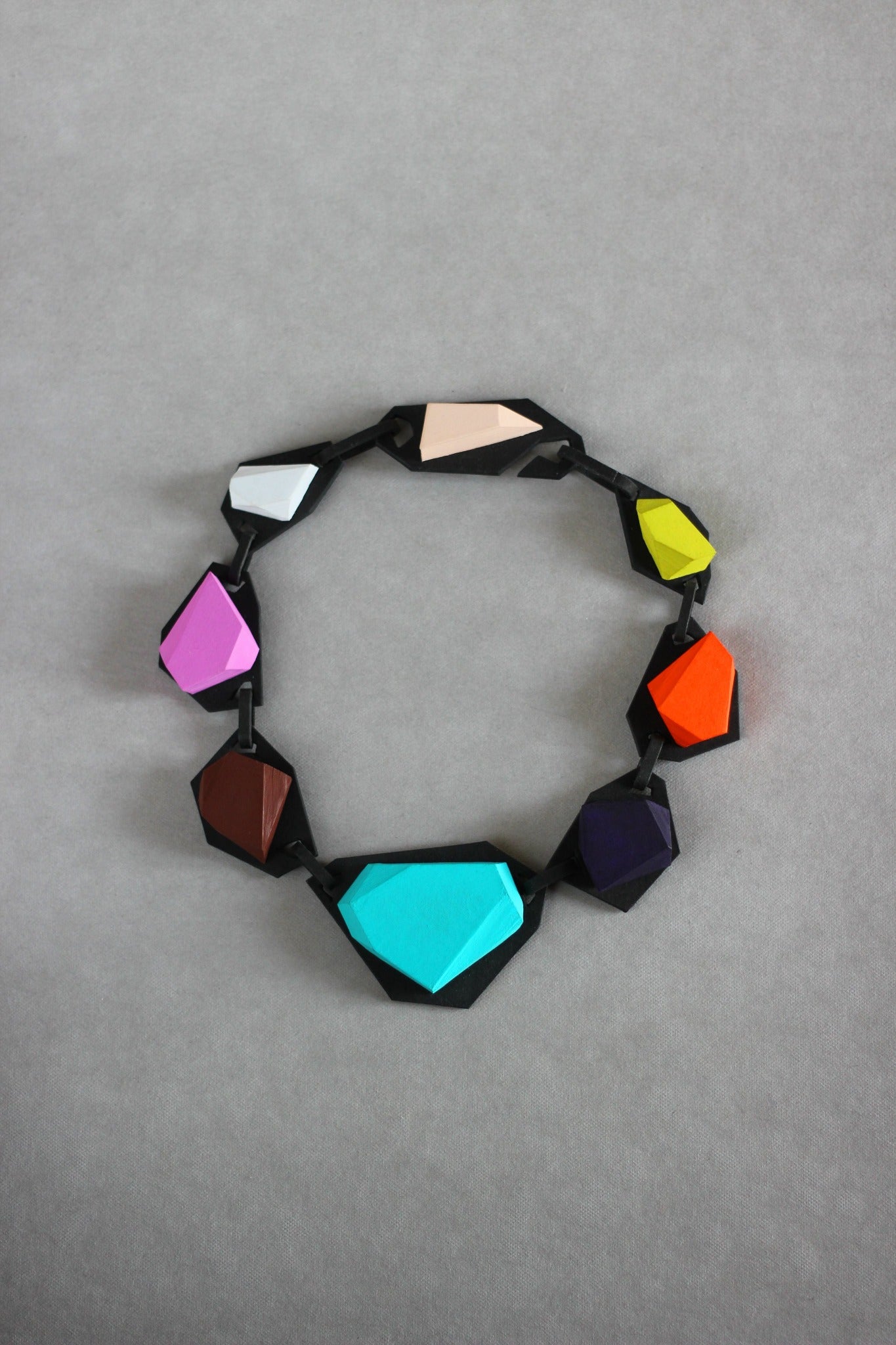 Langackerhäuslの幾何学ネックレス「KRISTL(クリストル)」。クリスタルの結晶のような多面体の黒いピースが連なる、軽量で知的なハンドメイドペーパージュエリー。