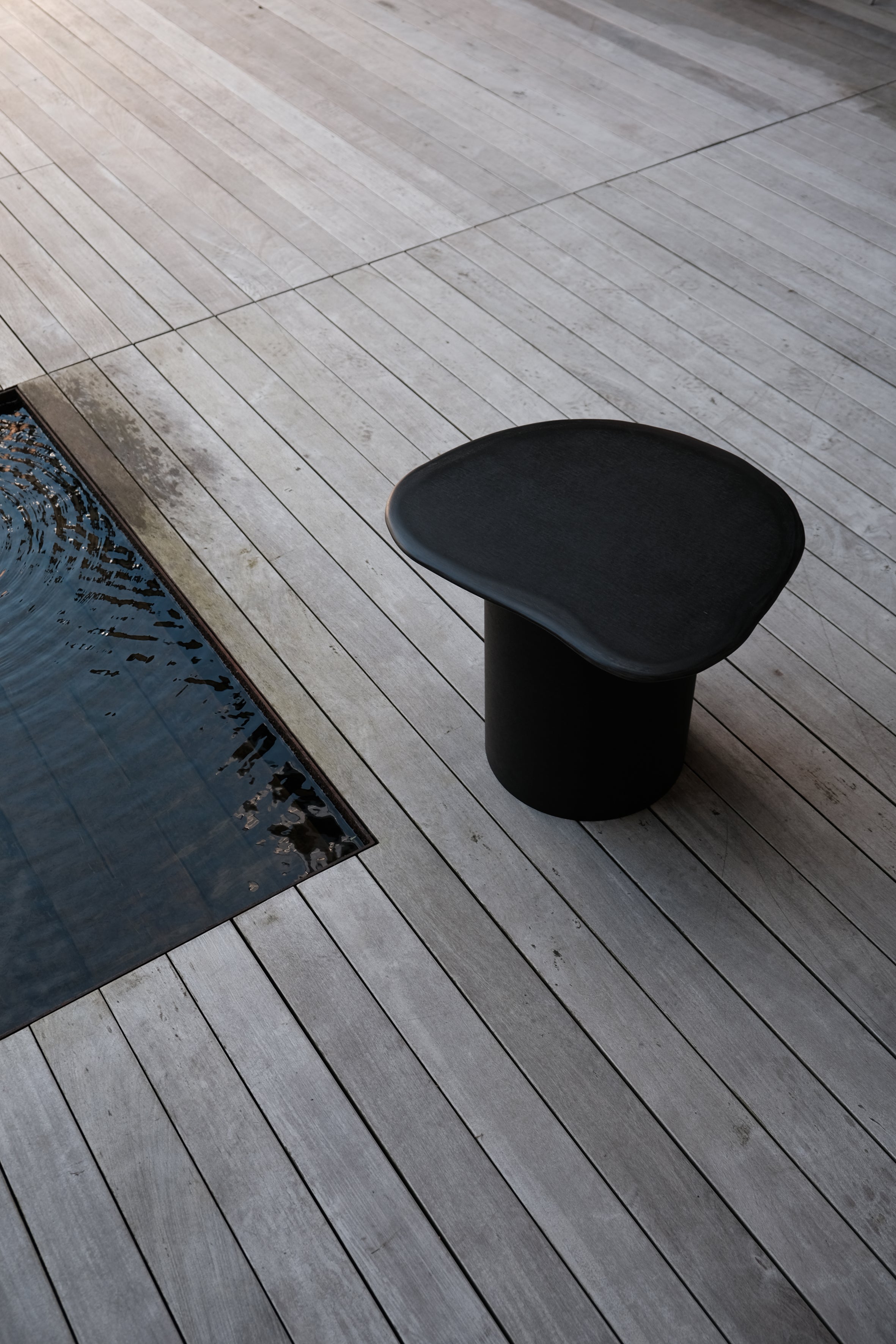 Langackerhäuslのペーパースカルプチャー・サイドテーブルSLATE（スレート）。石のような滑らかな天板と円筒形の台座を100%紙で構築した、高さ45cmのマットブラックが美しいオーストリア製ハンドメイド家具。