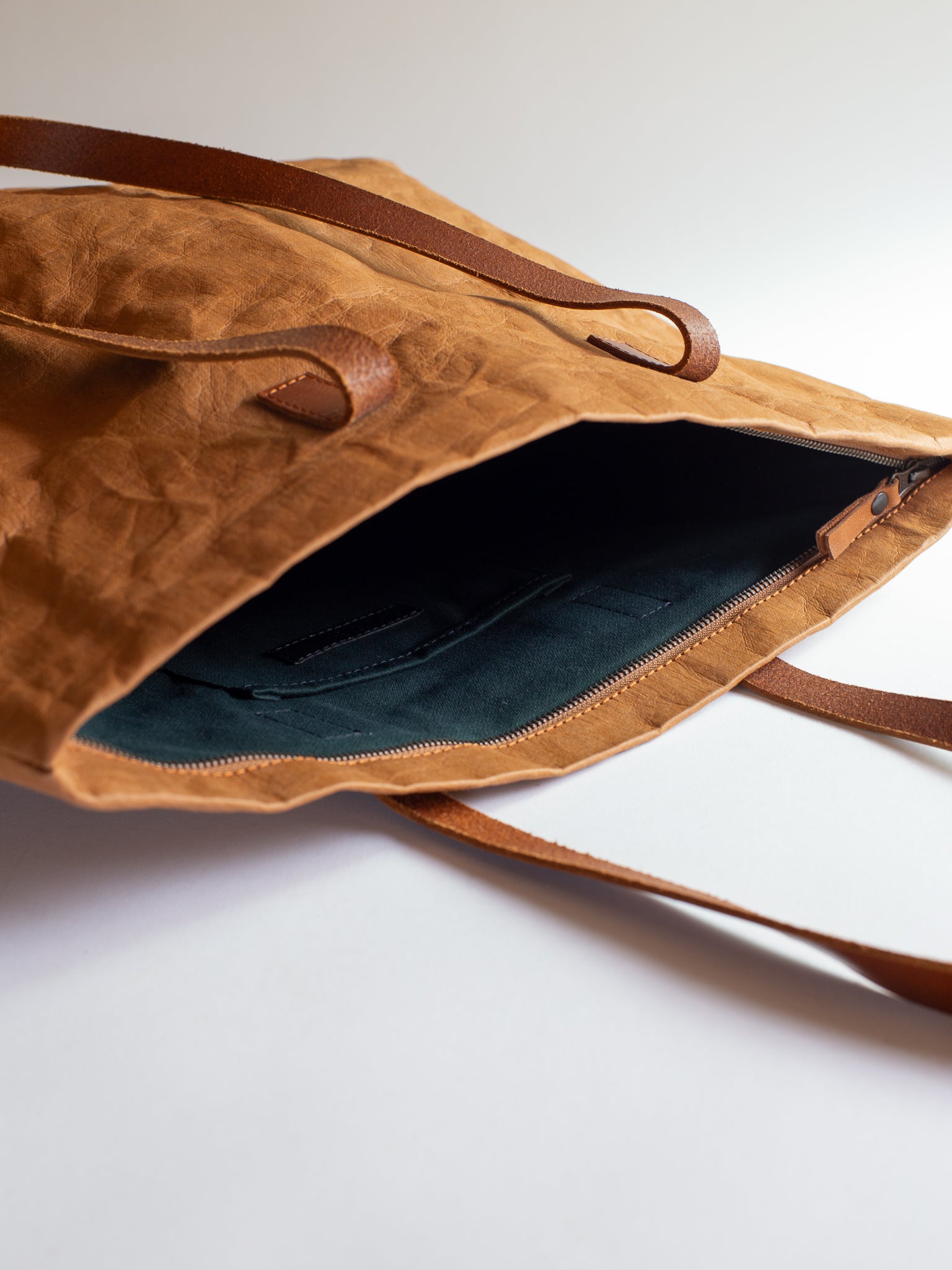 Langackerhäuslの草木染めビッグトートTRANSPORTER（トランスポーター）。タバックカラーの特殊加工紙とレザーストラップが調和する、圧倒的なサイズ感と軽さを両立したオーストリア製ハンドメイドバッグ。