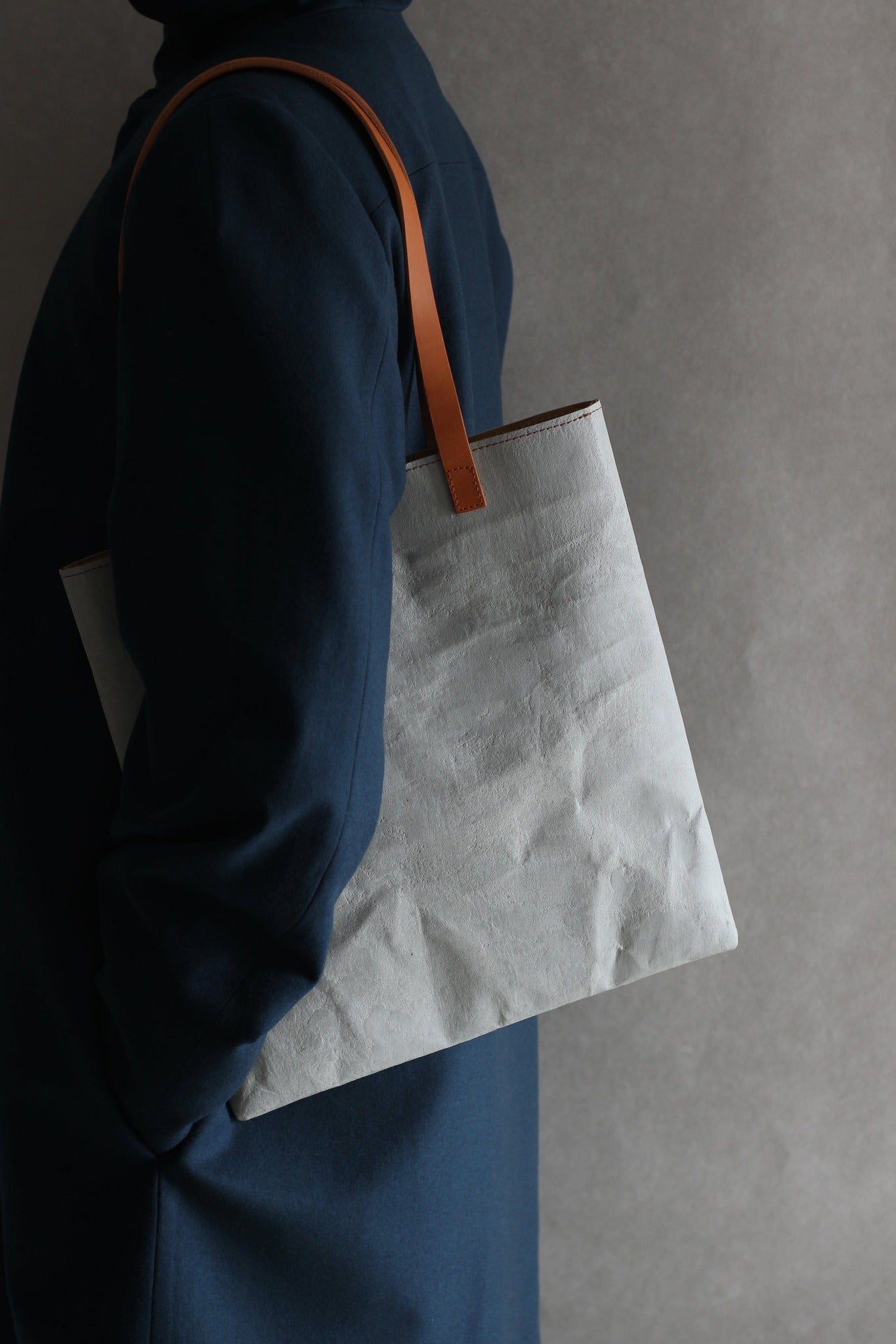 LangackerhäuslのコンクリートトートバッグSLEEVE（スリーブ）。コンクリートの質感と紙の柔軟性を併せ持つ独創的な素材を使用し、長いレザーハンドルがアクセントを添えるオーストリア製ハンドメイド縦型トート。
